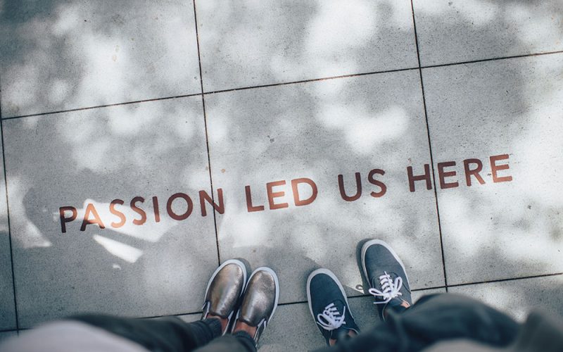 Two people stand on a pavement with the words “PASSION LED US HERE” written on the paving, surrounded by dappled sunlight—an inspiring scene for anyone embarking on their HR recruitment journey.